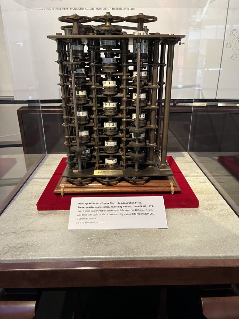A mechanical computer built mostly of brass, with various numerical dials. A small placard labels this as a replica of the Babbage Difference Engine No. 1 Demonstration Piece.